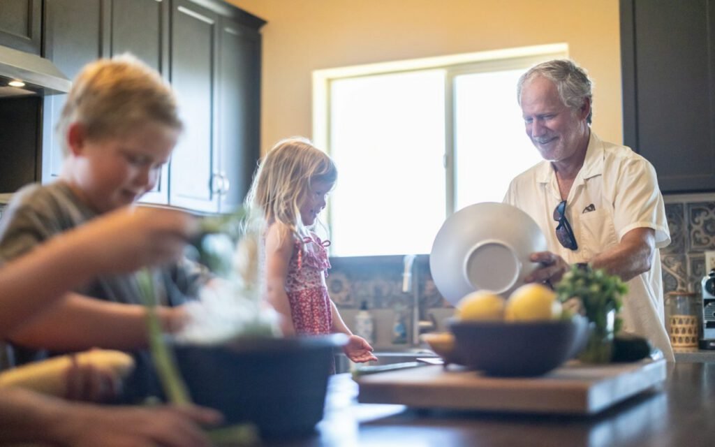 A grandfather spending time with family in a home kitchen