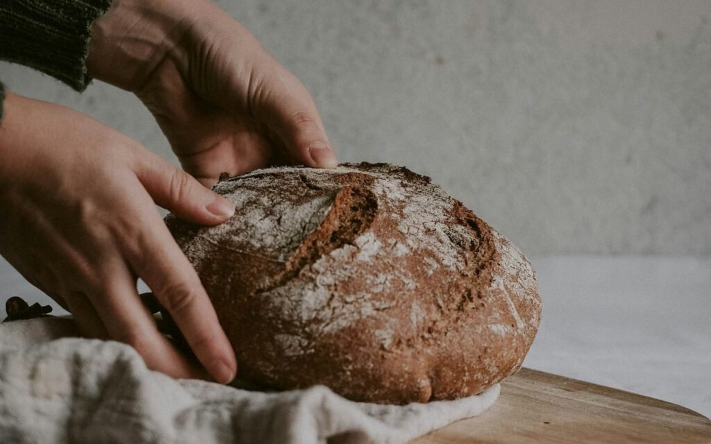 A round loaf of sourdough bread on a wooden board