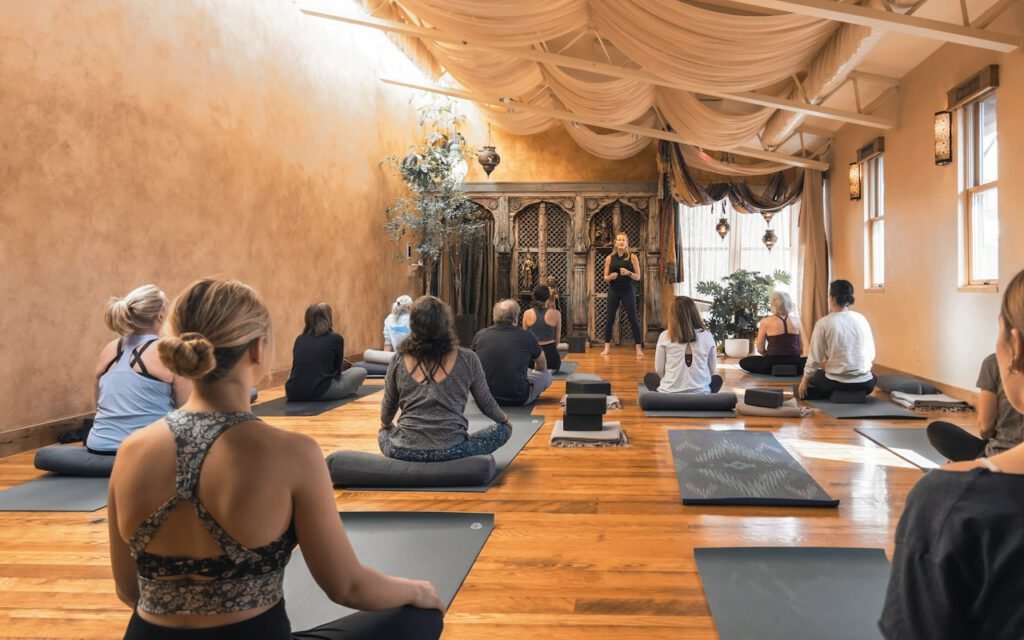 A group of students practicing yoga together in a bright studio