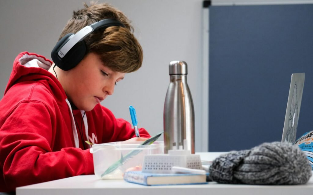 A young student wearing headphones and concentrating