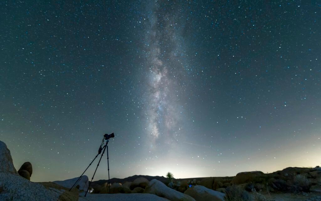 A clear night sky filled with stars above a dark horizon