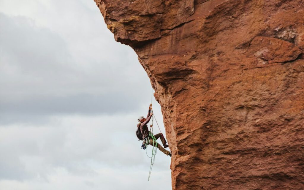 Climber reaching for a hold on a steep rock face