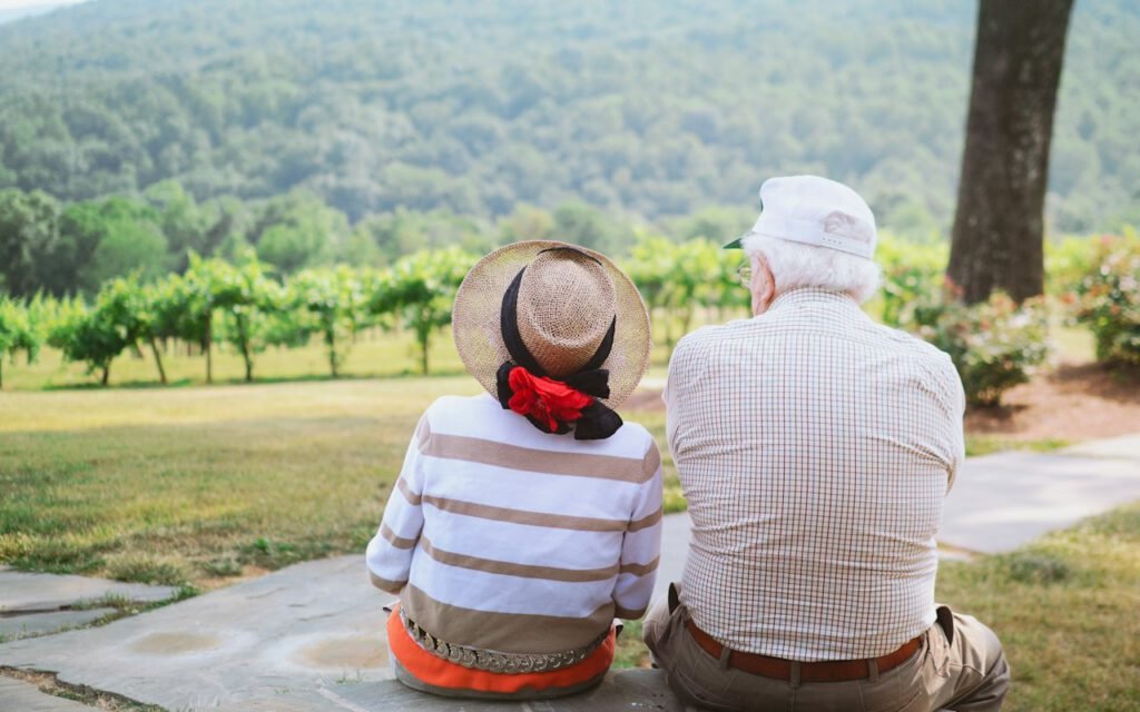 Two older adults walking together on a sunny path