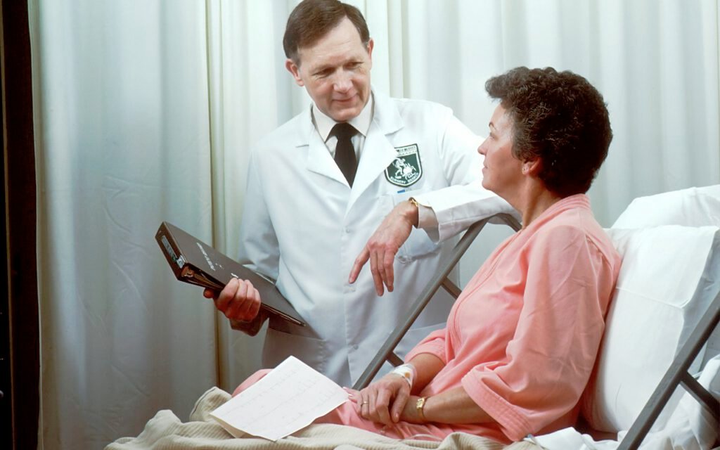A nurse speaking with a patient in a hospital room