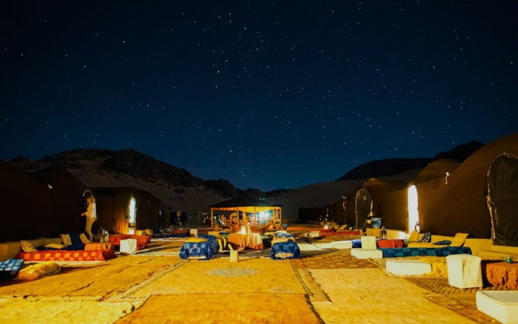 People stargazing near a campsite under a starry sky