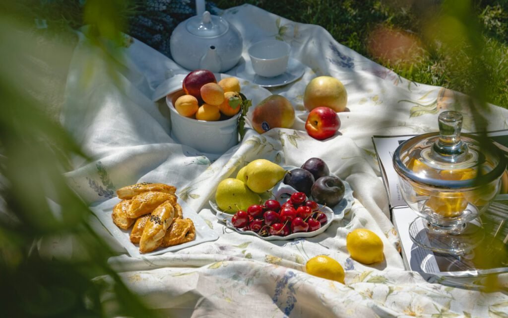 A picnic blanket spread on the grass in a sunny park