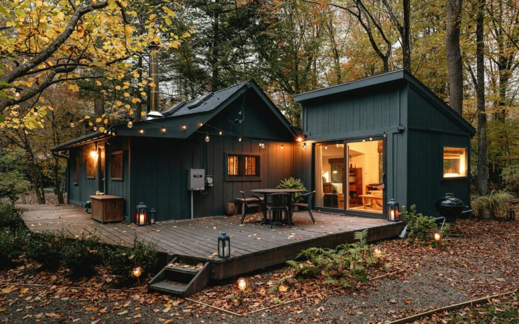 A wooden cabin with a deck surrounded by trees