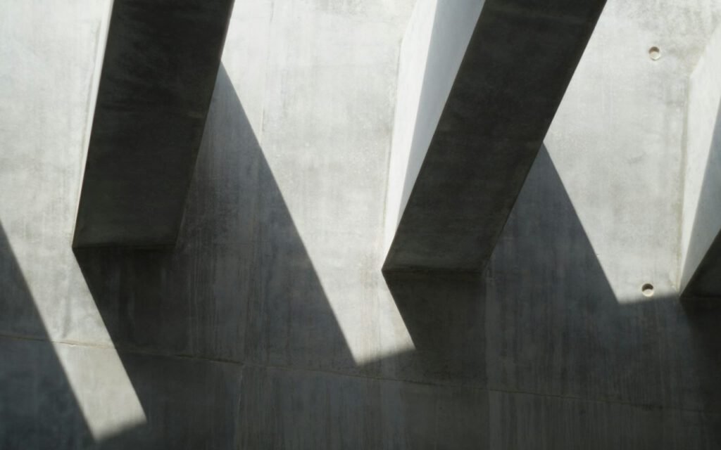 Sharp afternoon shadows falling across a pale architectural wall