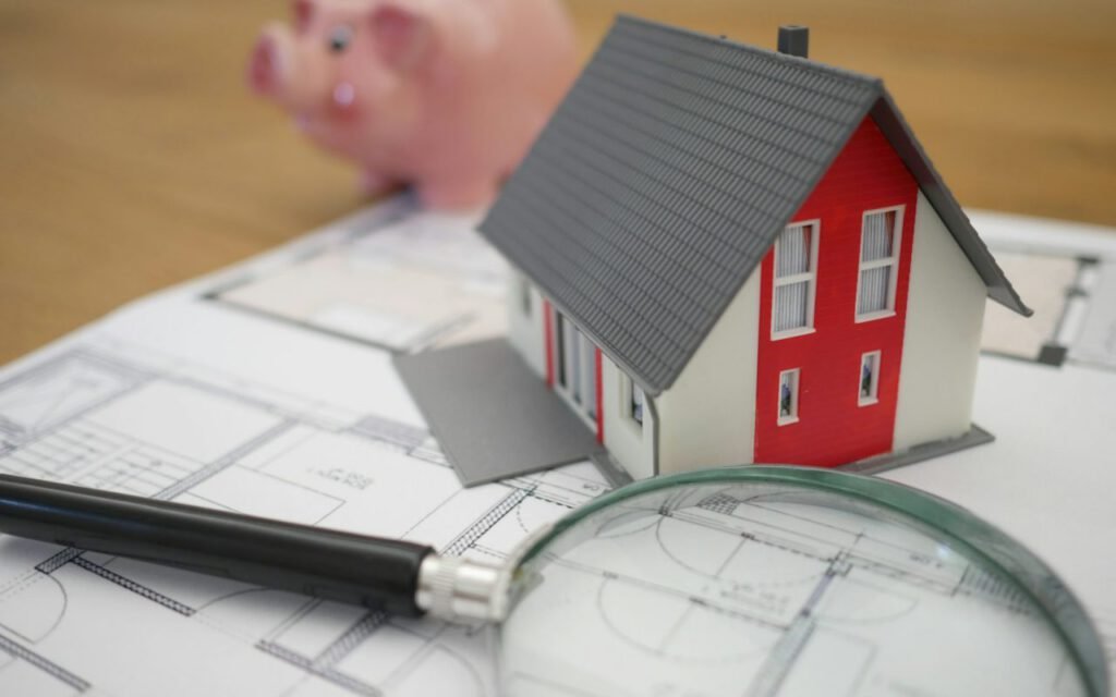An architectural model of a house resting on drawn plans