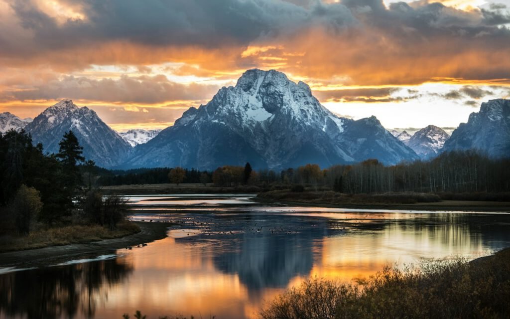 A calm mountain lake surrounded by forest and peaks