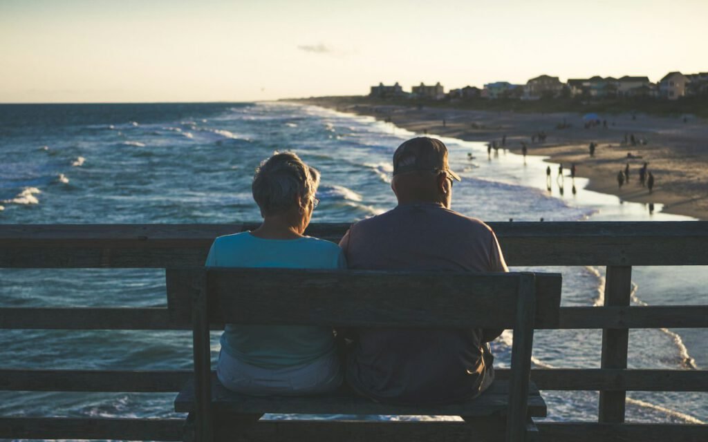 A retired couple relaxing together on a sunny beach