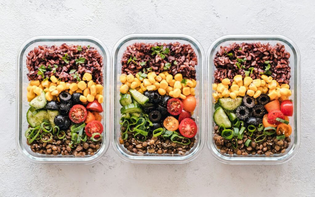 Meal prep containers filled with rice, vegetables and chicken