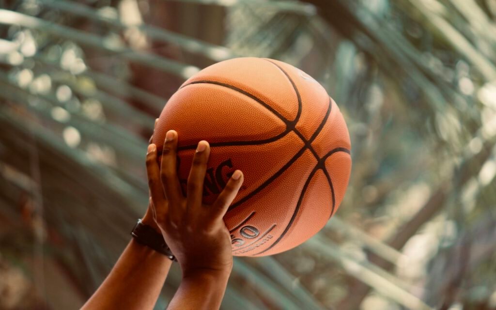 A basketball hoop and backboard under arena lights