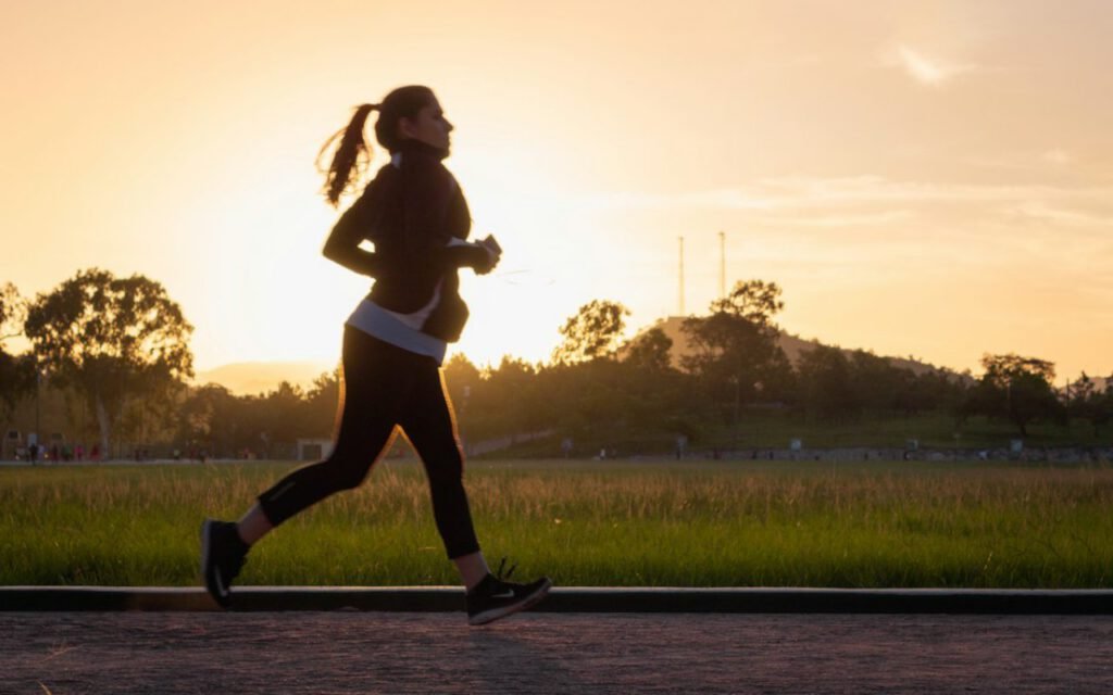 A runner silhouetted against a golden sunset sky