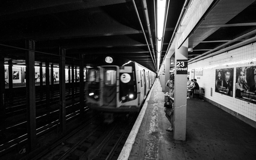 A subway train arriving at a busy underground platform