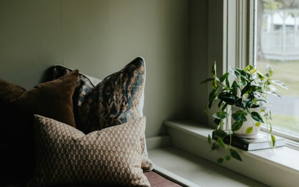A cozy reading nook with a cushioned window seat and books