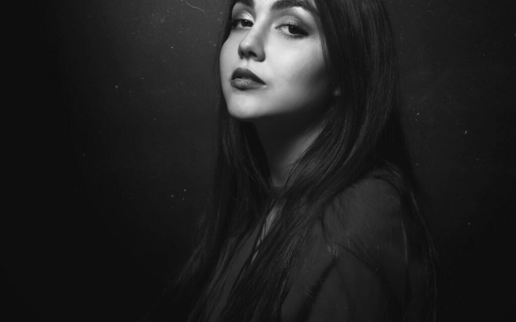 A relaxed black and white portrait of a person looking toward the camera