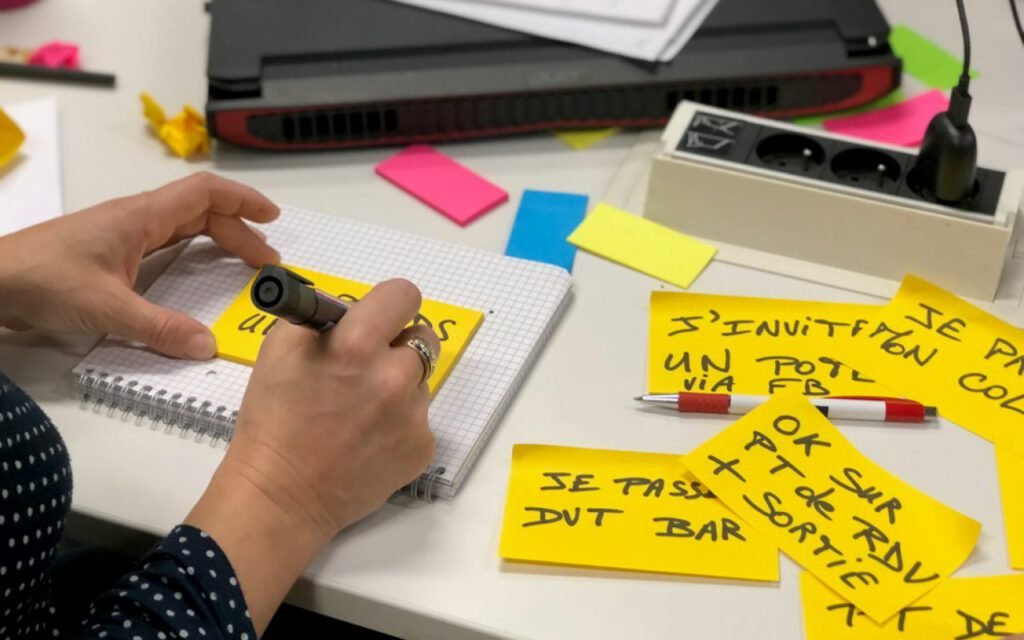 Hand writing tasks on sticky notes during a planning session
