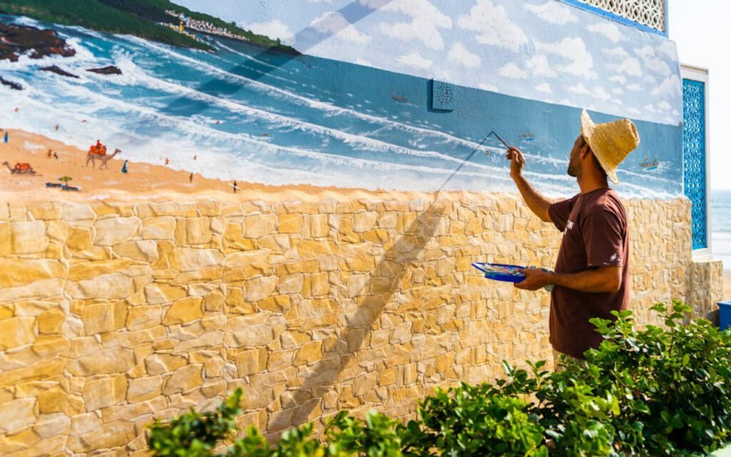 A large colorful mural being painted on a wall