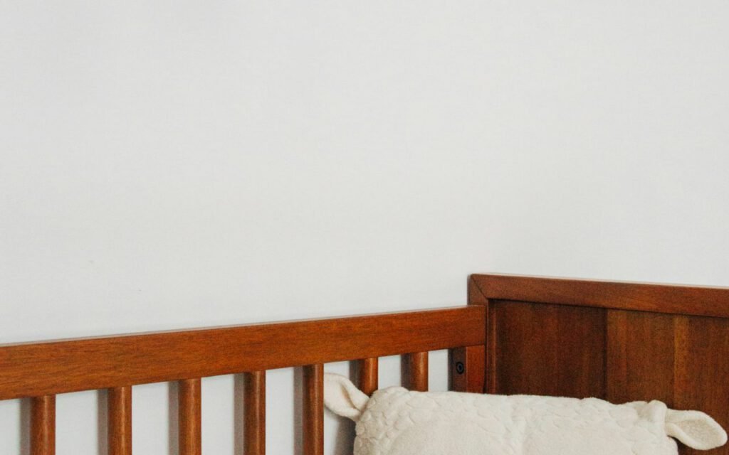A crib with a colorful hanging mobile in a nursery