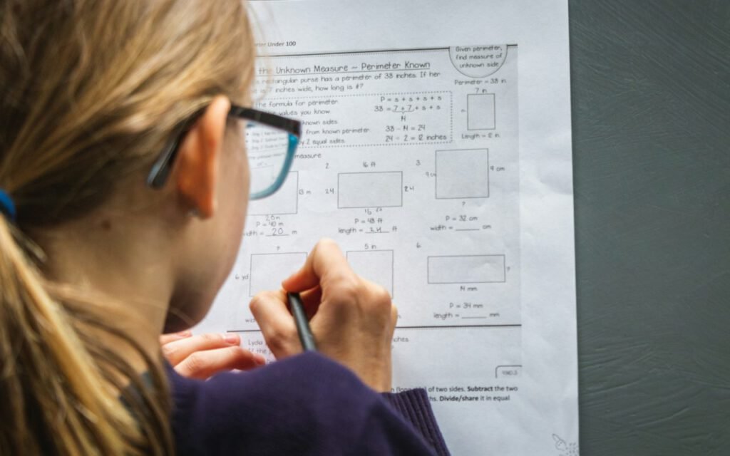 Young girl working on a school worksheet at a table