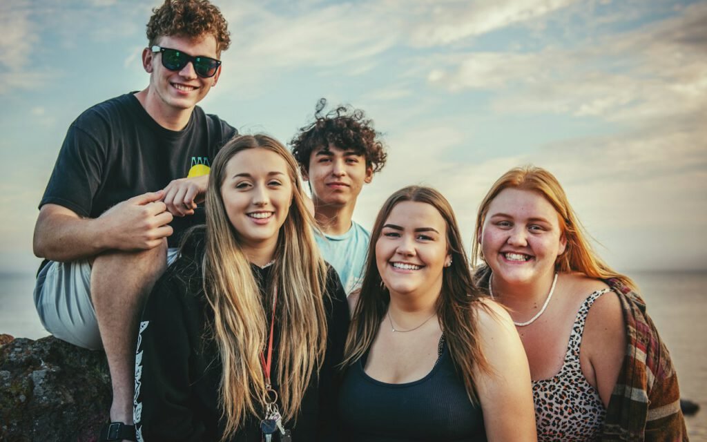 A group of young people standing together outdoors and smiling