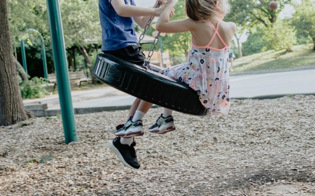 A child on a swing at a neighborhood playground