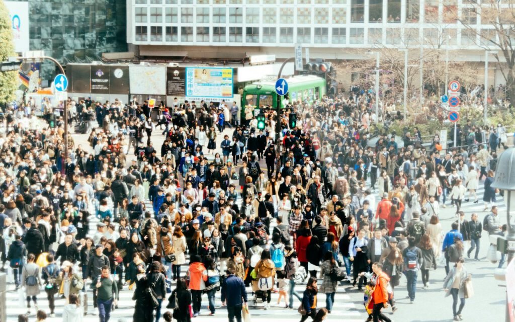 A crowd of people walking together through a busy outdoor event