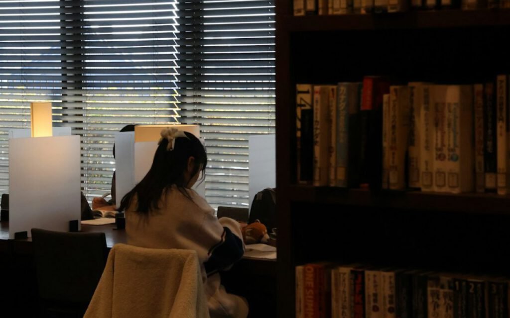 Long wooden tables and shelves in a quiet public library reading room