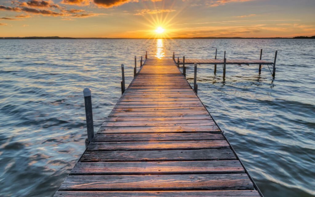 Wooden dock stretching out over calm gray water