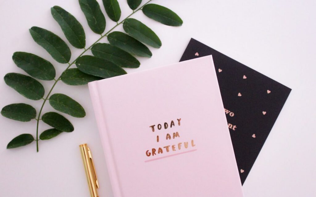 Hands writing short notes in a small notebook