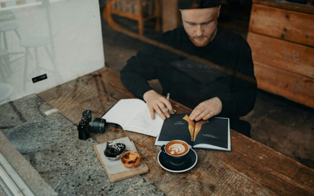 Person writing in a notebook at a café table