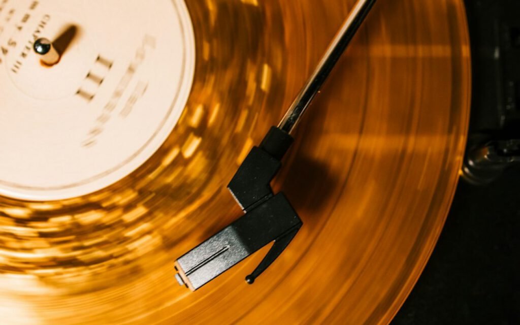 A stack of vinyl records next to a record player