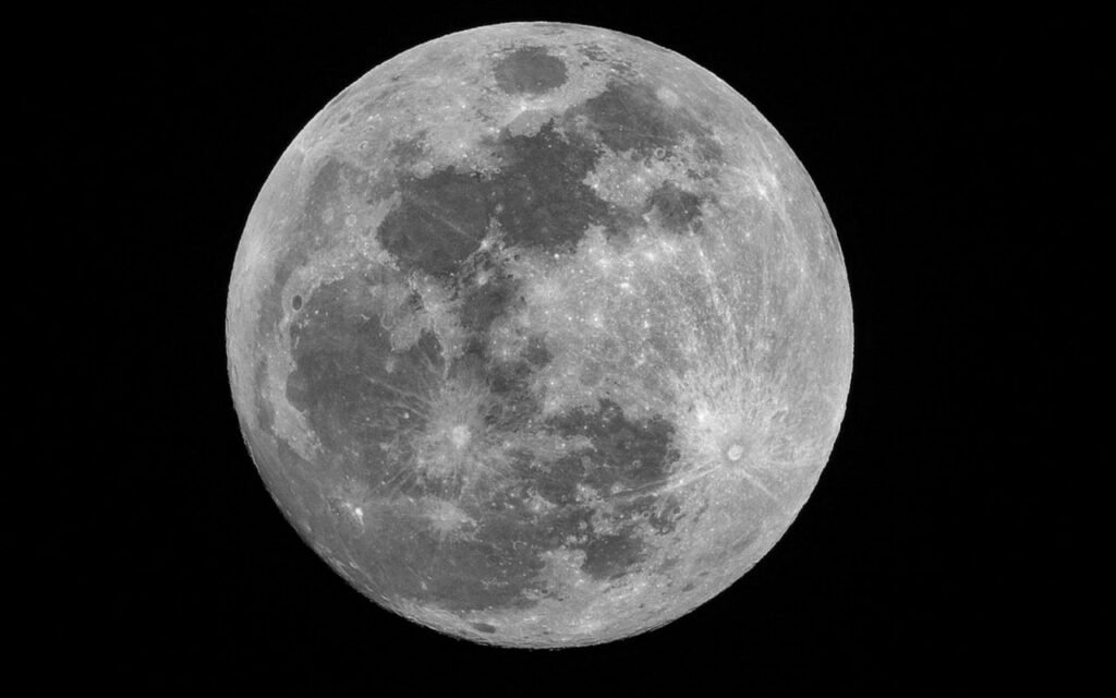 A glowing full moon against a dark night sky