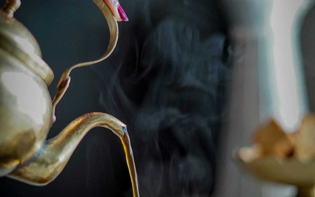 Hot tea being poured into a cup on a quiet afternoon