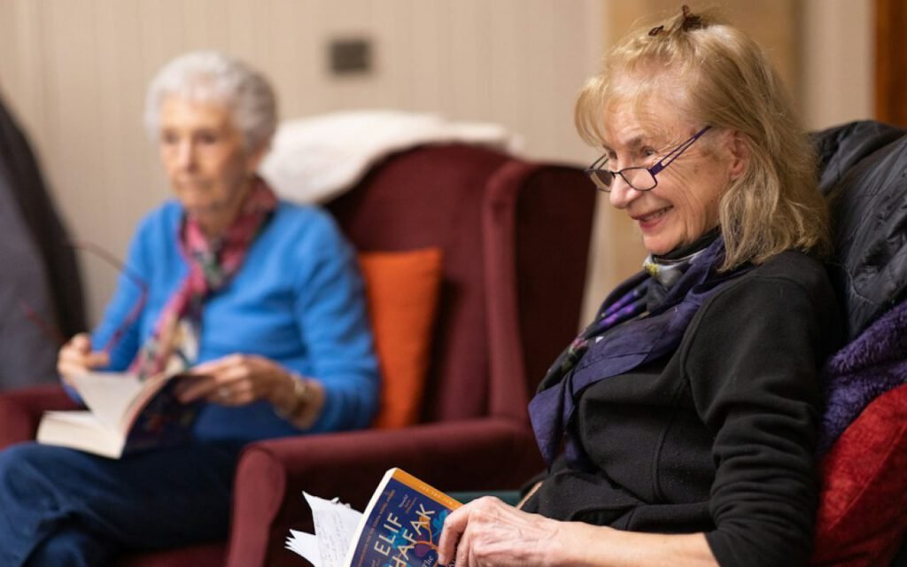 A small group of people discussing books around a table