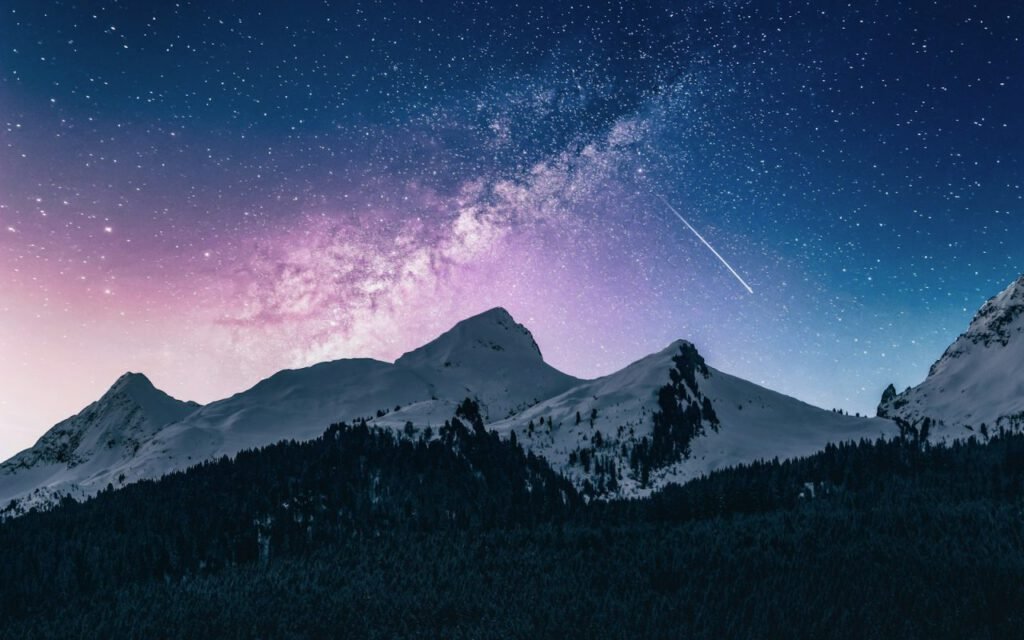 The Milky Way stretching across the sky above mountain peaks