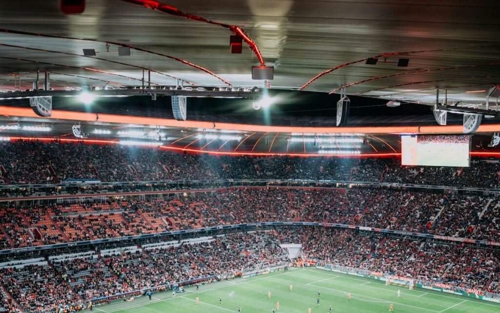 A soccer stadium lit up at night with fans in the stands