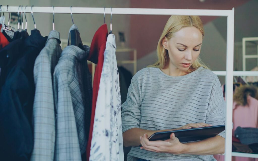 A boutique owner arranging clothing in her small shop