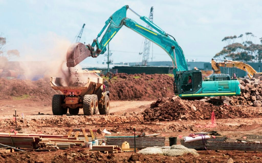 Excavator clearing debris at a work site