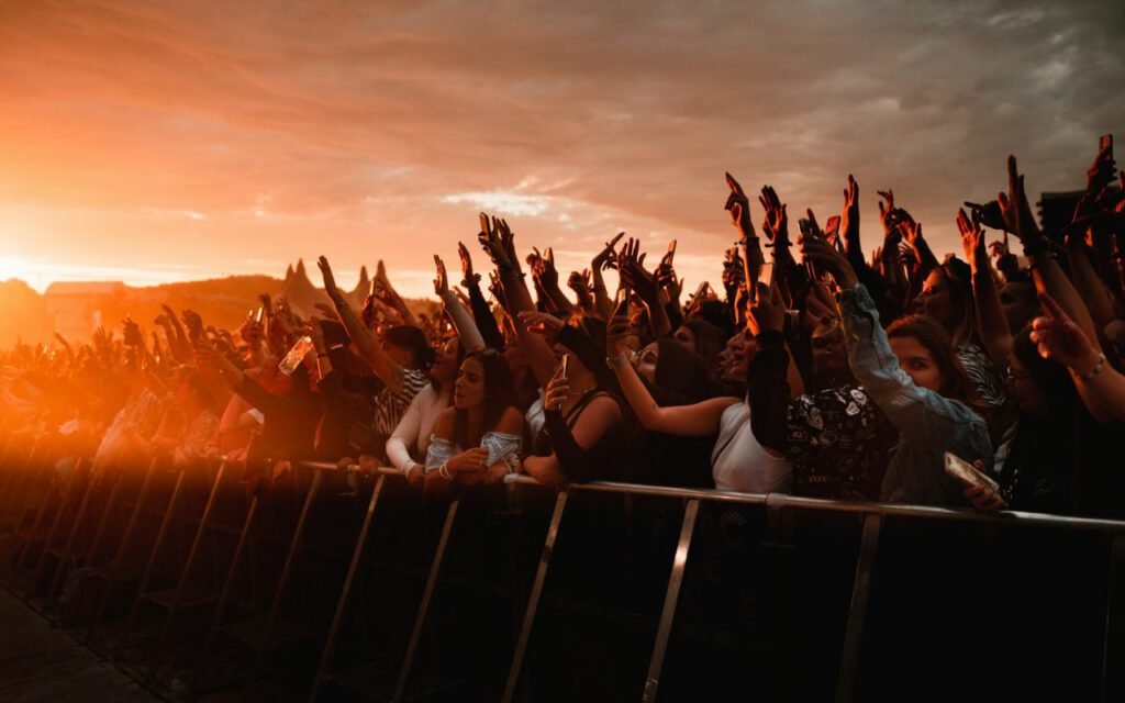 A crowd enjoying an outdoor concert in golden evening light