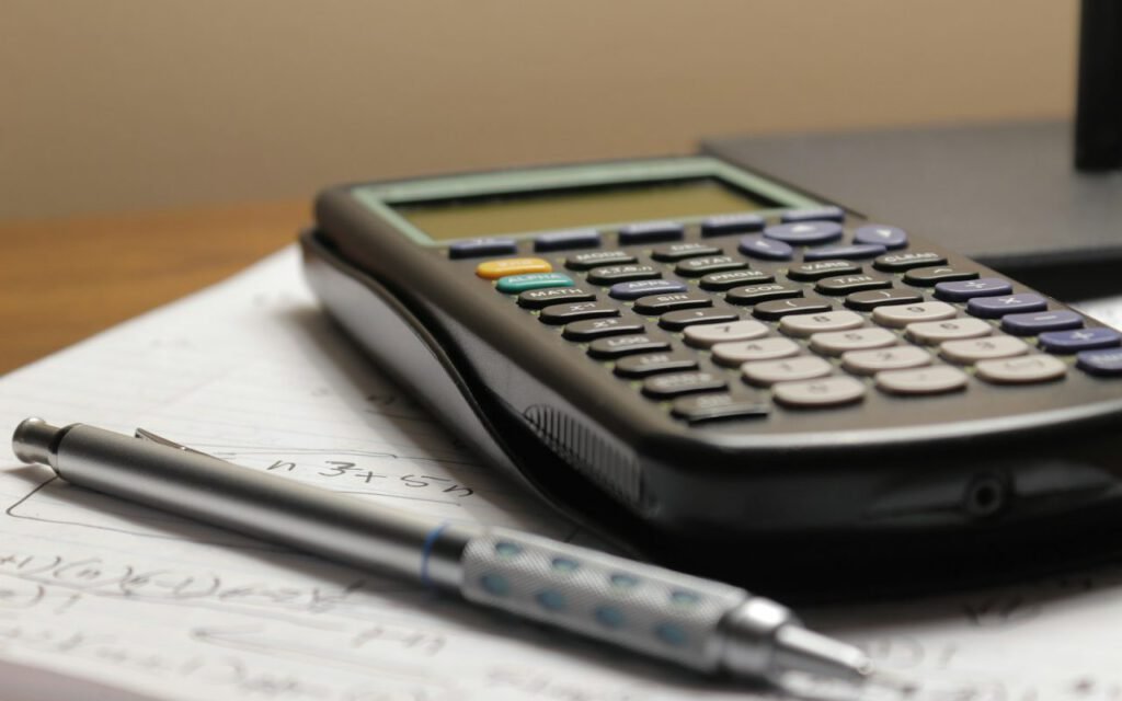 A calculator and paperwork on a desk for budget planning