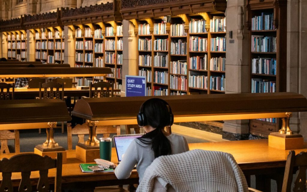 Student studying with books at a library table