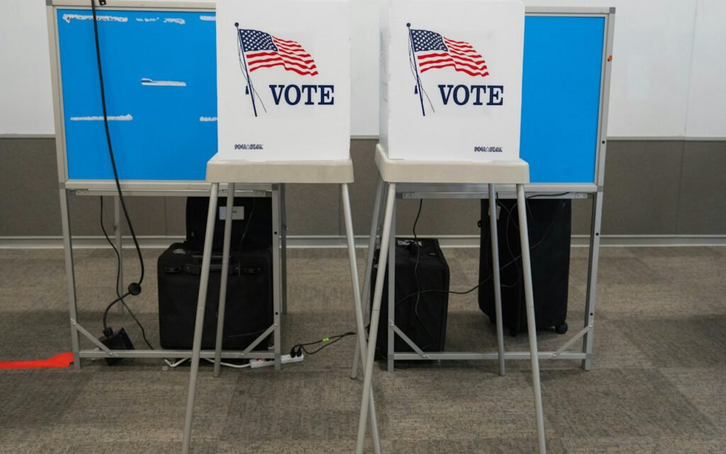A row of voting booths set up inside a polling place