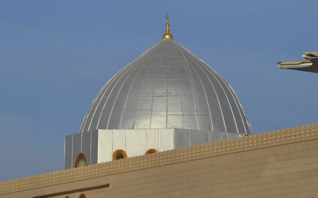 The white dome of a mosque against a clear sky