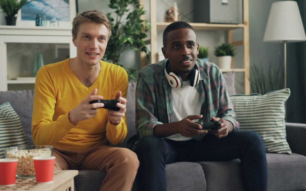 Friends playing video games together on a couch