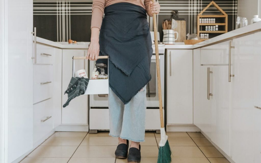 A person sweeping a bright, clean kitchen floor