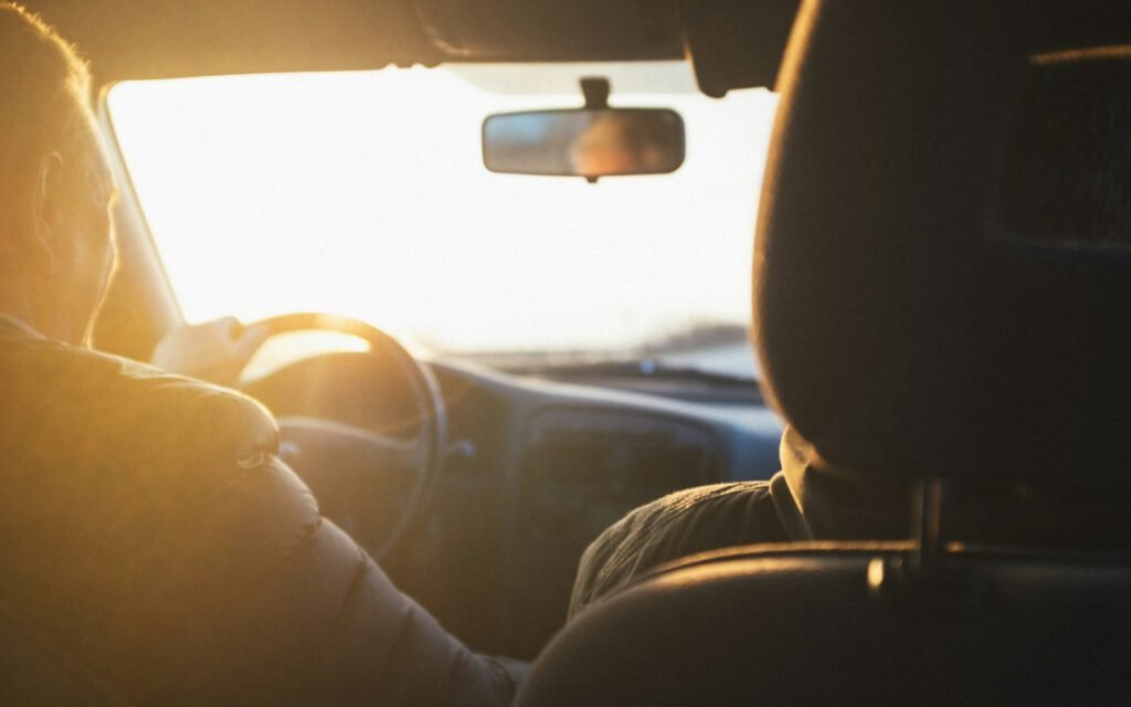 A car driving along an open road at sunset