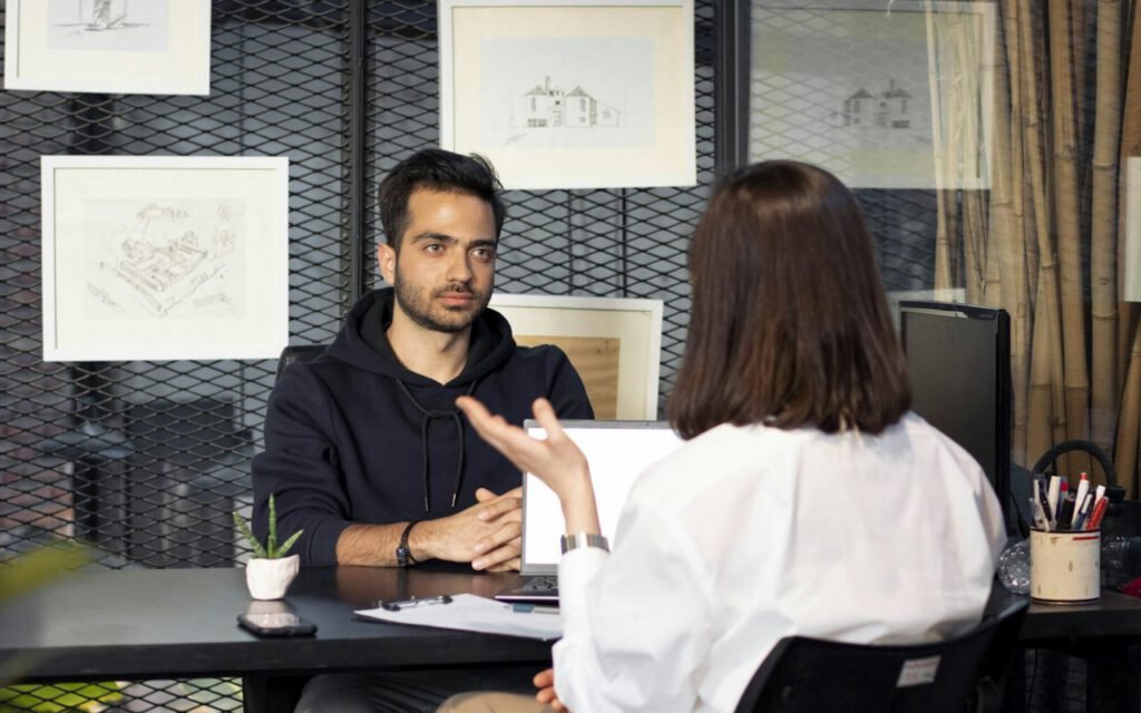 A candidate and an interviewer talking across a desk