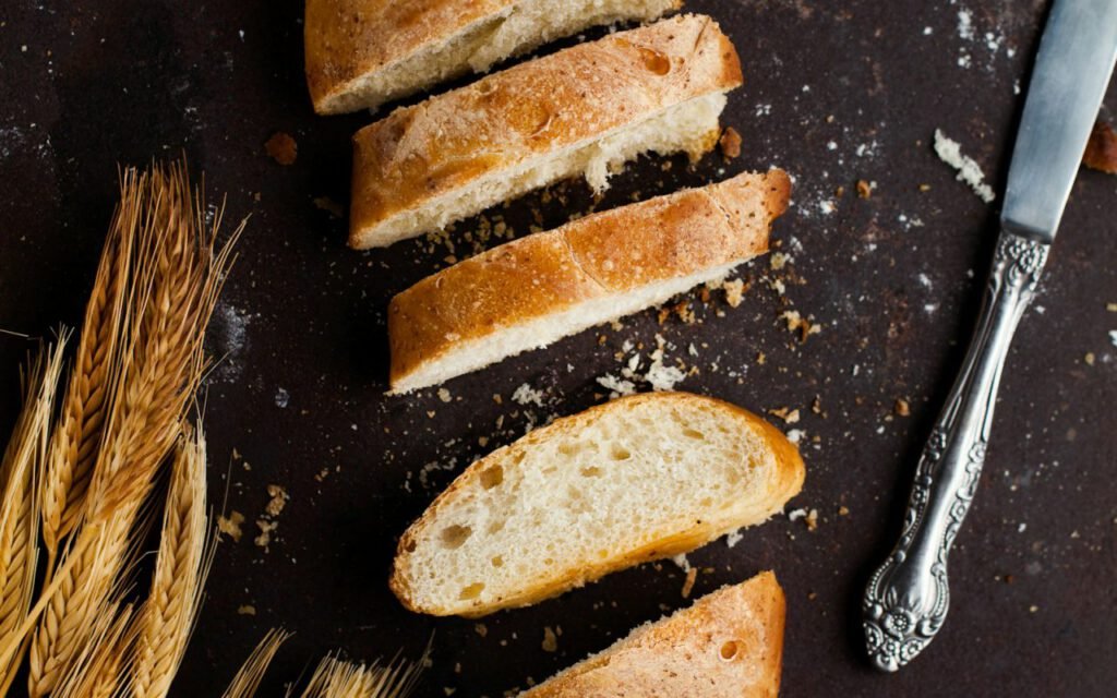 Loaf of fresh bread sliced on a wooden board